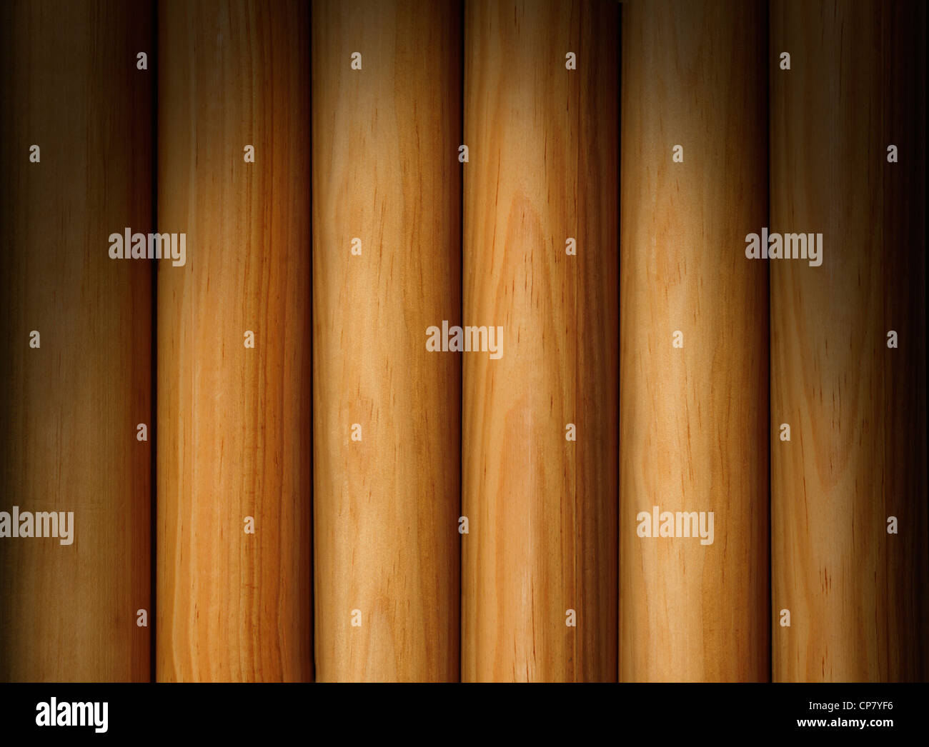 Poteaux en bois formant une texture d'arrière-plan éclairé de façon spectaculaire au-dessus Banque D'Images