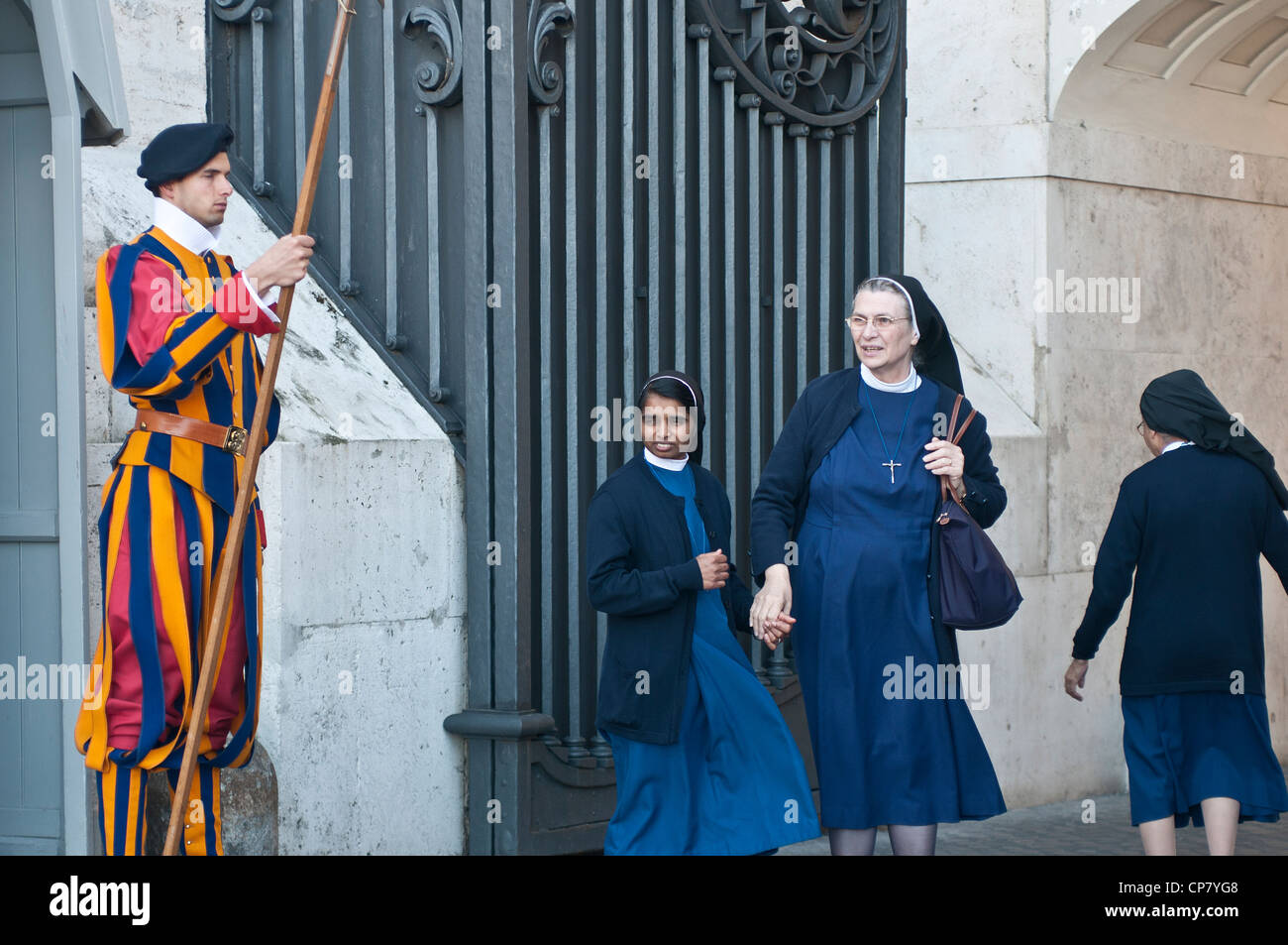 Garde suisse et les nonnes entrant dans la porte de la Cité du Vatican Banque D'Images