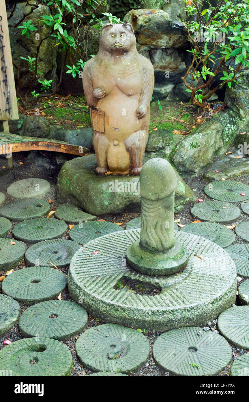 Phallus en pierre et avec une grande statue du raton laveur à testicules Taga Jinja, Uwajime, Shikoku, Japon Banque D'Images
