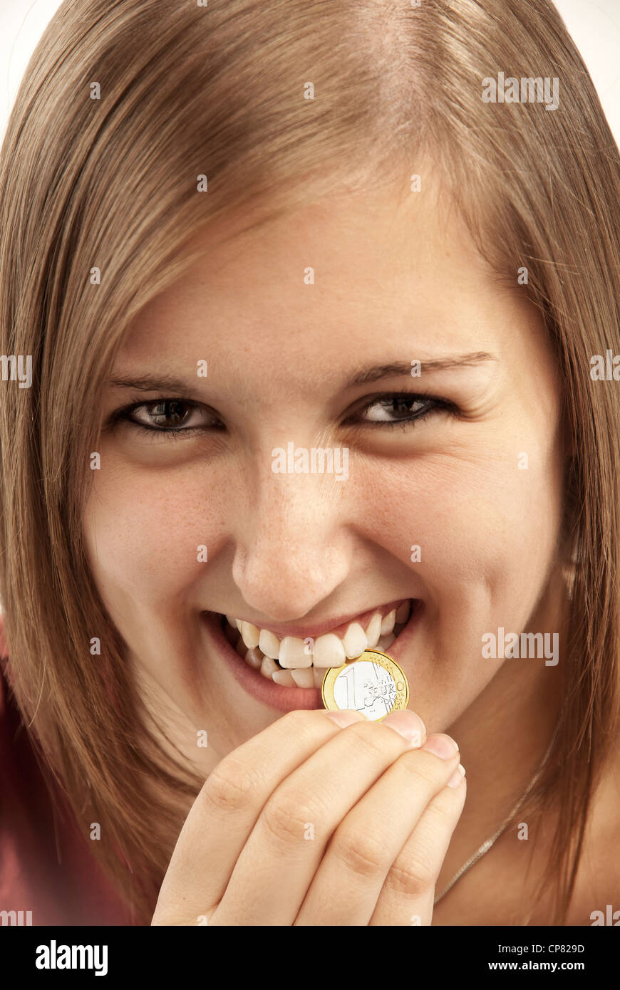 Young woman biting sur un € pièce. Banque D'Images