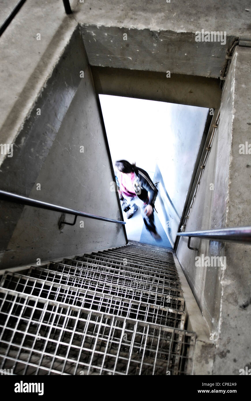 Un escalier mène dans une cave. Ci-dessous la silhouette d'un homme s'affiche. Banque D'Images