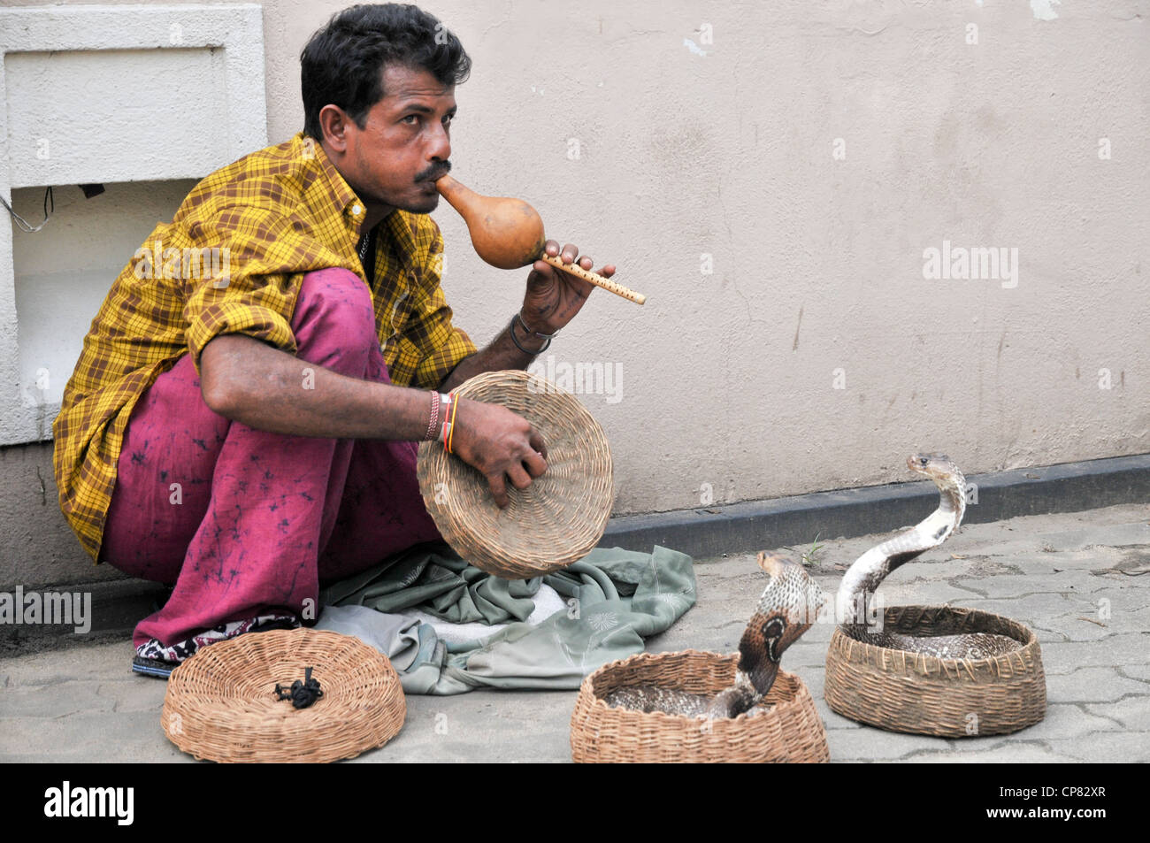 Un snakecharmer, Sri Lanka. Il est charmant deux cobras à lunettes dans des paniers. Banque D'Images