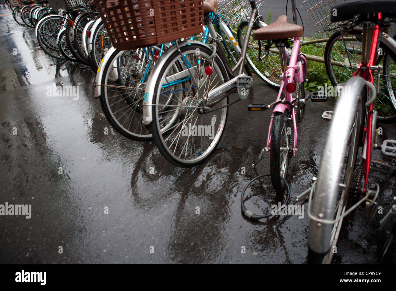 Les vélos garés sur un jour de pluie à Tokyo, Japon. Banque D'Images