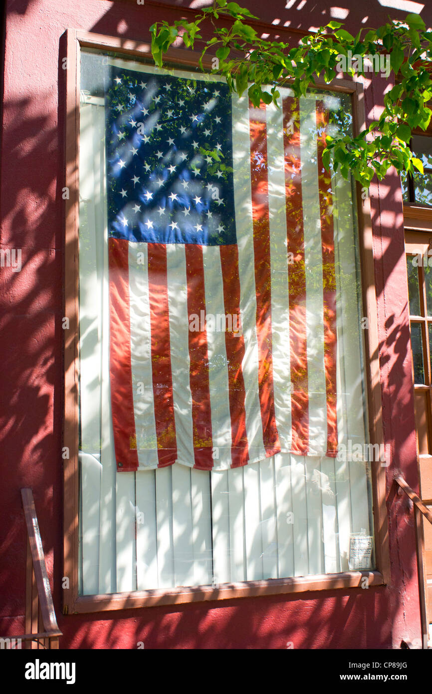 Le drapeau Américain suspendu dans une fenêtre d'une maison de Soho à New York.. Banque D'Images