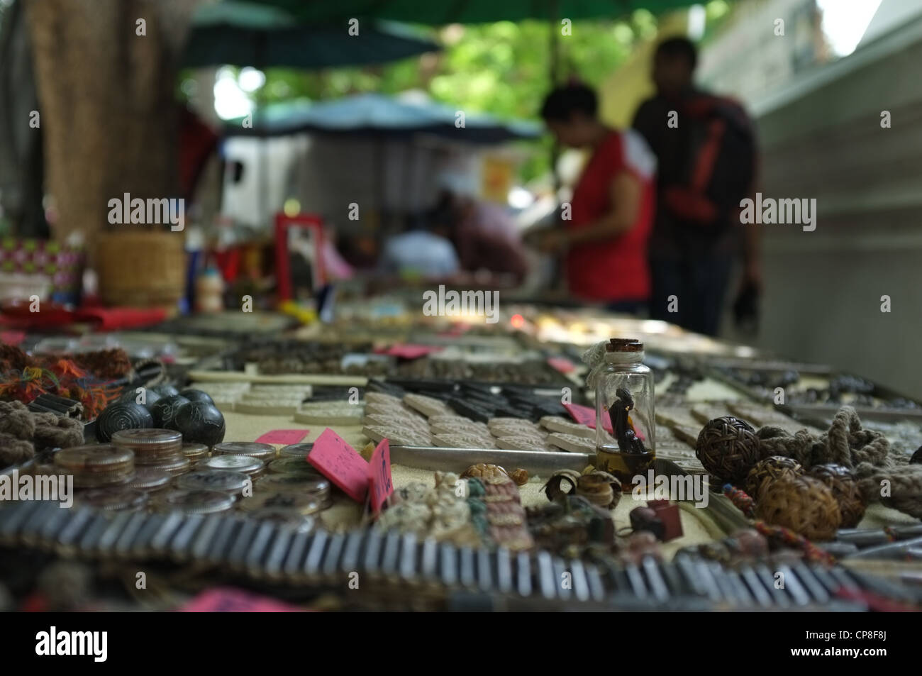 Une sélection de plats thaïlandais et de protection amulettes religieuses l'imagerie bouddhique en vente sur un marché à Bangkok près de Wat Mahathat temple. Banque D'Images