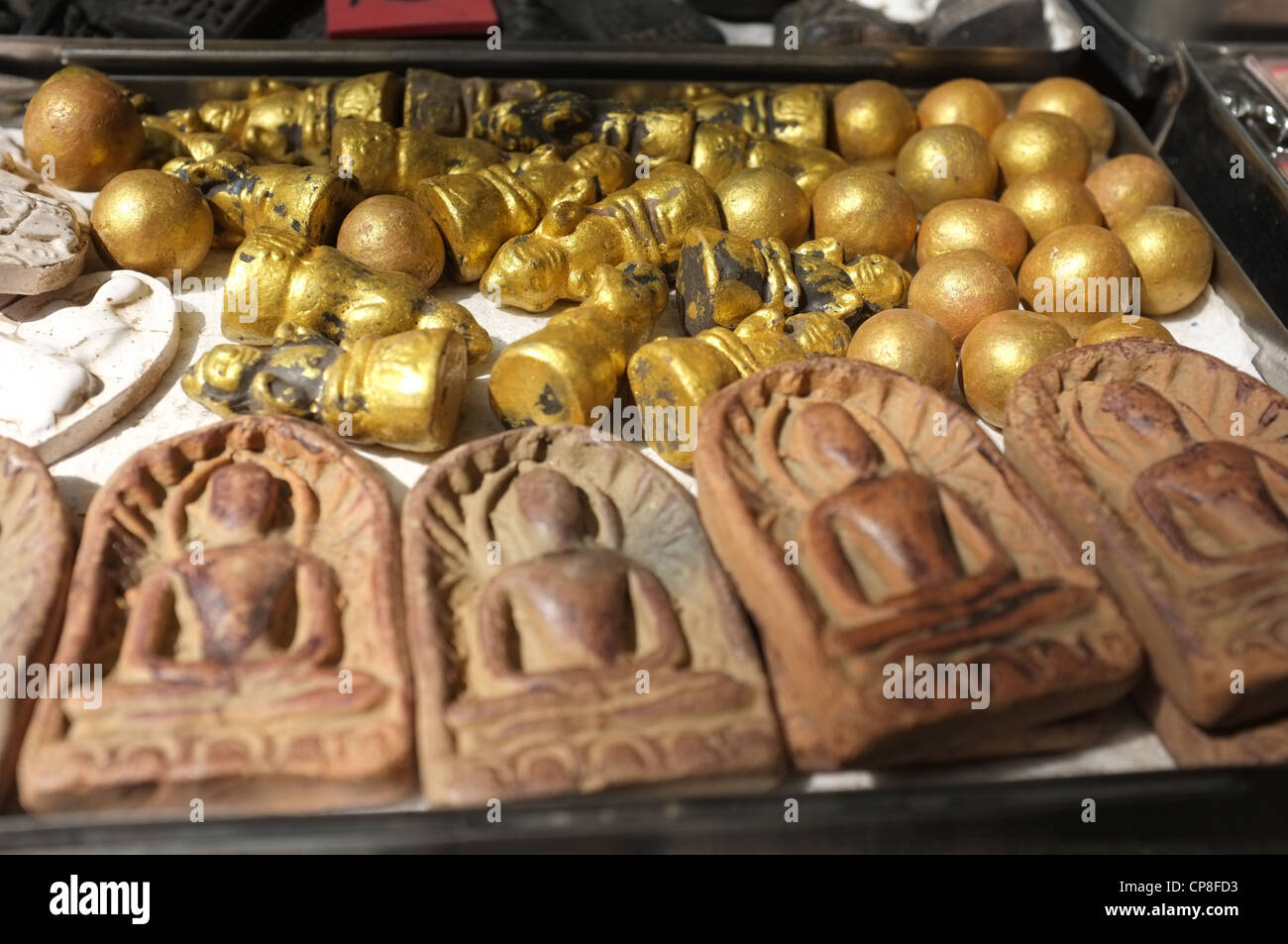 Une sélection de plats thaïlandais et de protection amulettes religieuses l'imagerie bouddhique en vente sur un marché à Bangkok près de Wat Mahathat temple. Banque D'Images