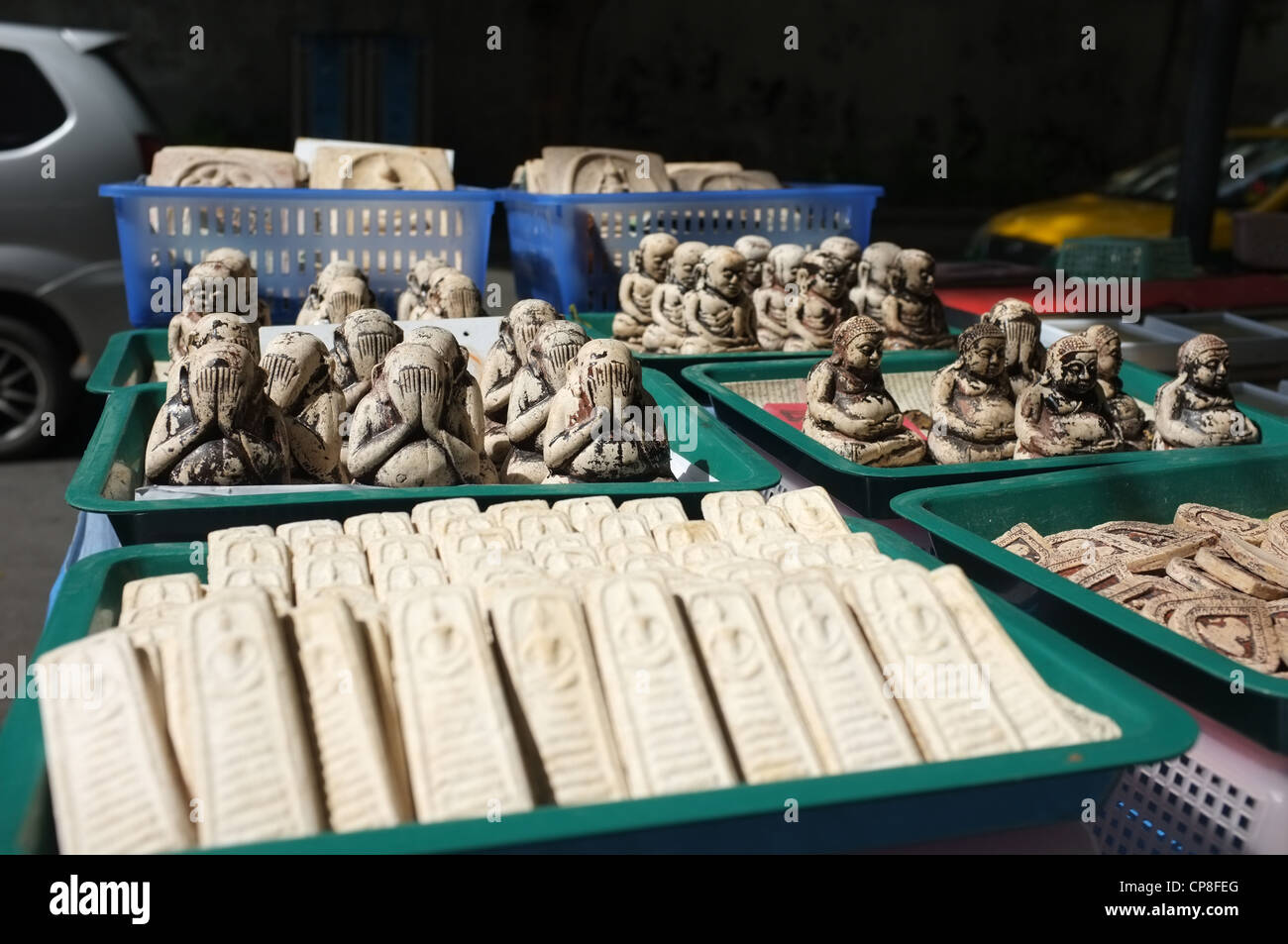 Une sélection de plats thaïlandais et de protection amulettes religieuses l'imagerie bouddhique en vente sur un marché à Bangkok près de Wat Mahathat temple. Banque D'Images