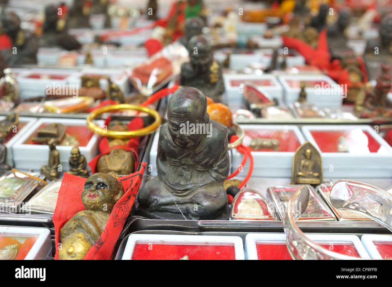 Une sélection de plats thaïlandais et de protection amulettes religieuses l'imagerie bouddhique en vente sur un marché à Bangkok près de Wat Mahathat temple. Banque D'Images