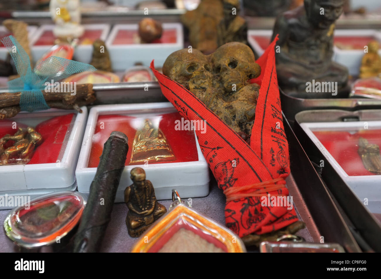 Une sélection de plats thaïlandais et de protection amulettes religieuses l'imagerie bouddhique en vente sur un marché à Bangkok près de Wat Mahathat temple. Banque D'Images