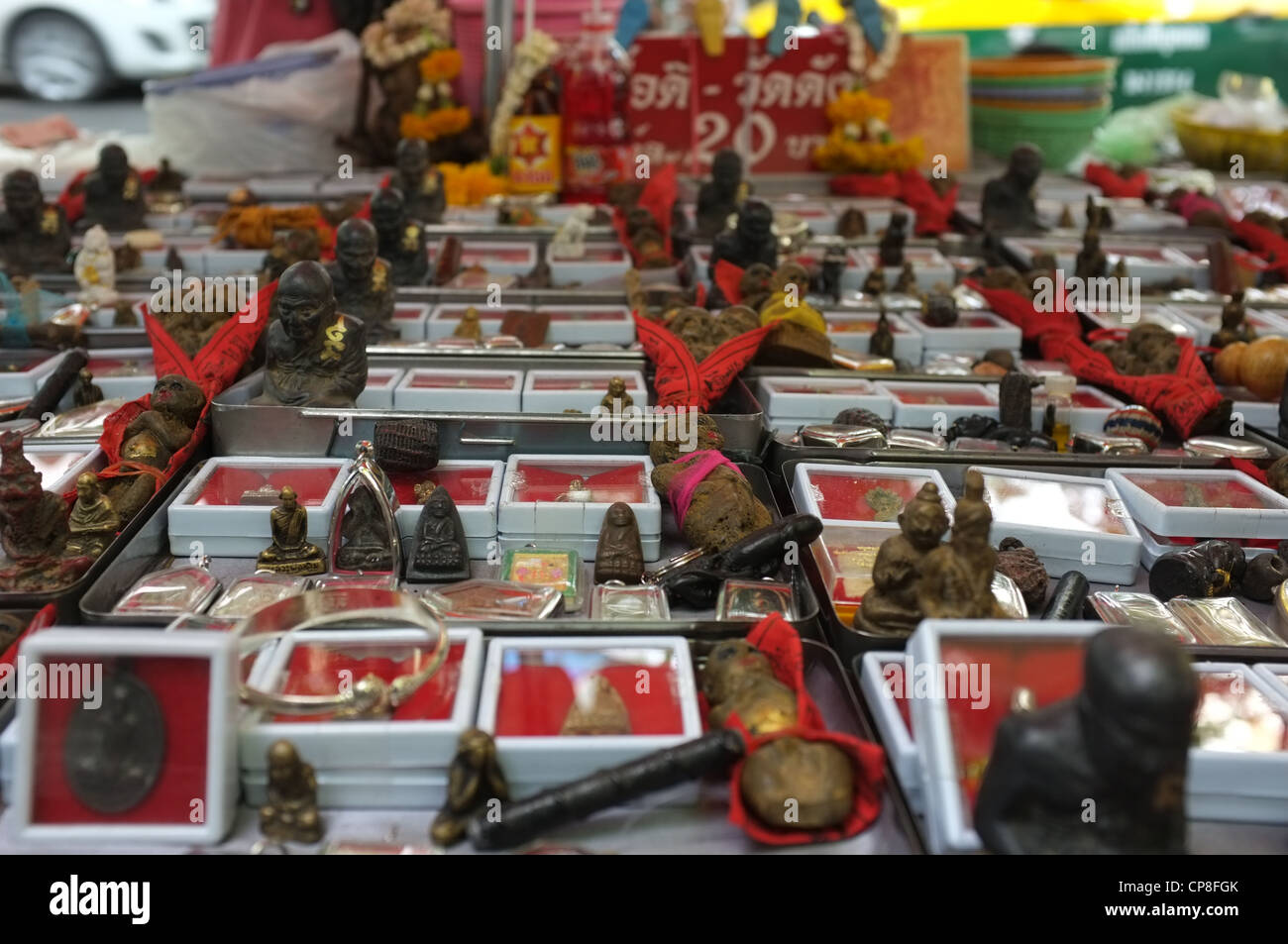 Une sélection de plats thaïlandais et de protection amulettes religieuses l'imagerie bouddhique en vente sur un marché à Bangkok près de Wat Mahathat temple. Banque D'Images