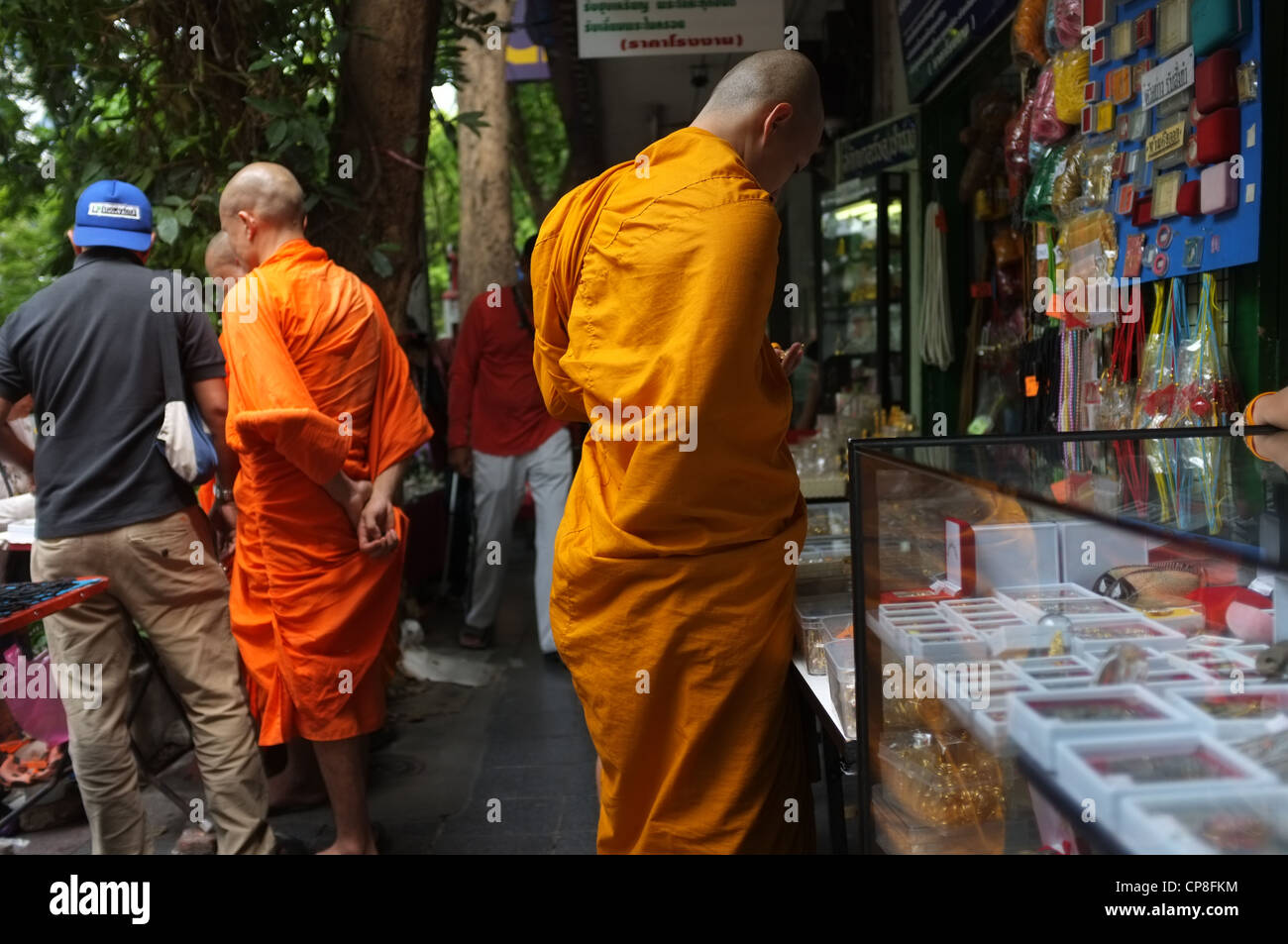 Les moines bouddhistes vu à la recherche d'amulettes de protection à un marché à Bangkok. Banque D'Images