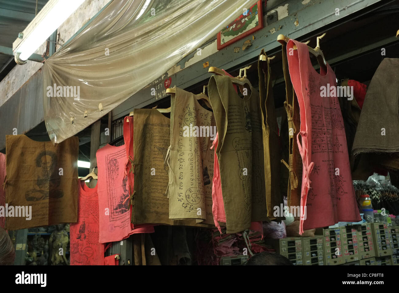 Une sélection de plats thaïlandais et de protection amulettes religieuses l'imagerie bouddhique en vente sur un marché à Bangkok près de Wat Mahathat temple. Banque D'Images