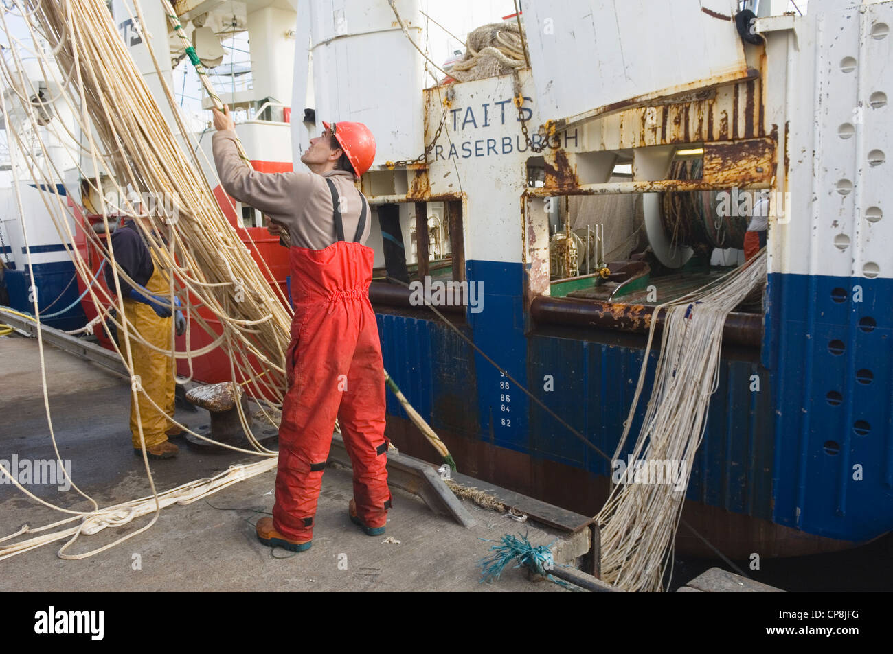 Pêcheurs travaillant avec les filets d'un grand chalutier de haute mer dans le port de Fraserburgh, Aberdeenshire, Ecosse. Banque D'Images