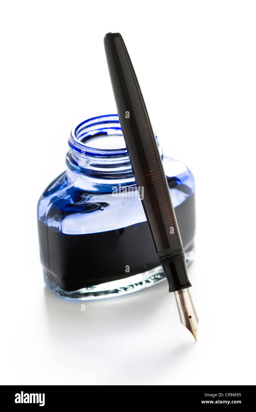 Un stylo plume appuyée sur une bouteille d'encre bleue isolé sur fond blanc Banque D'Images