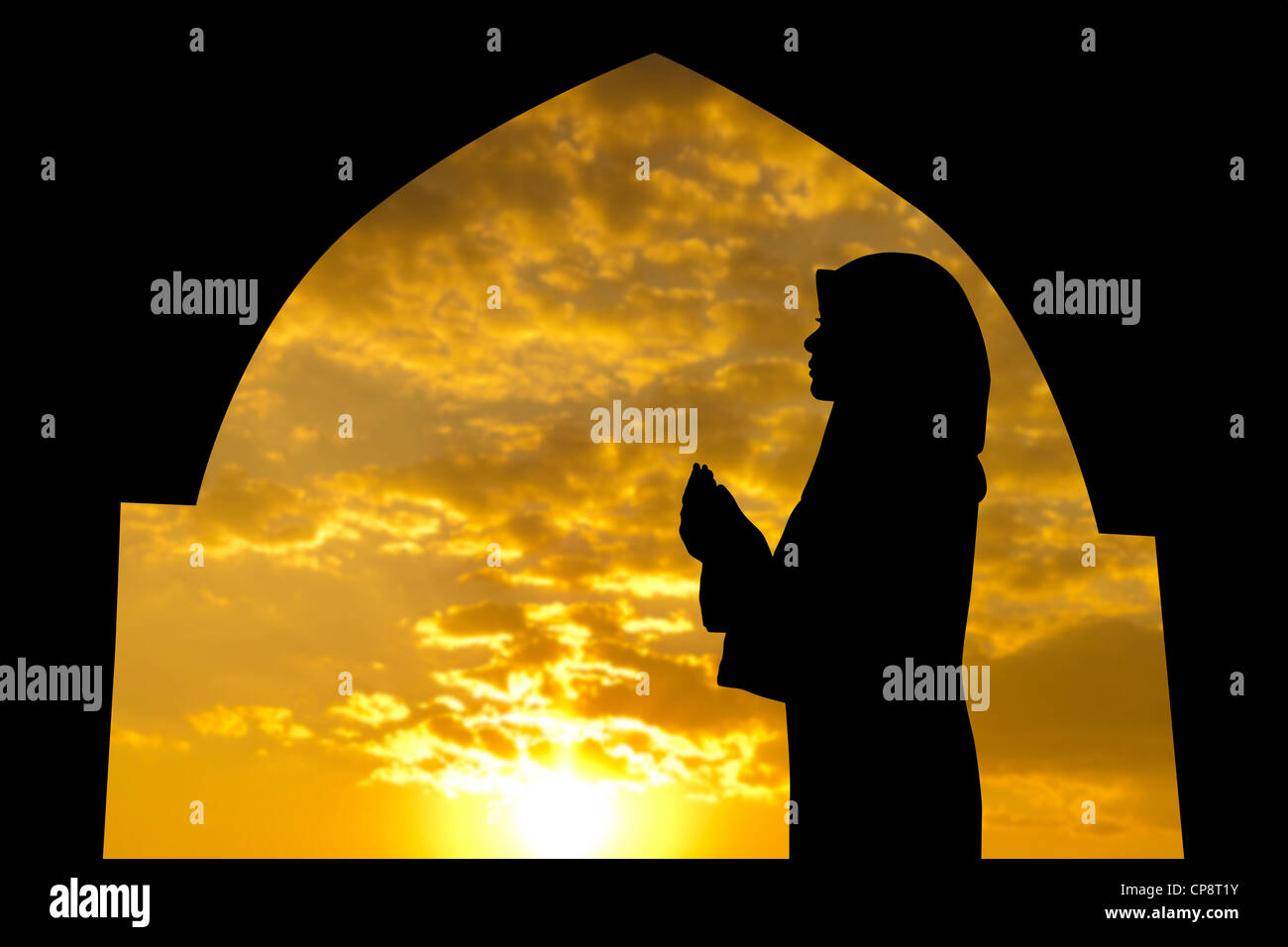 Silhouette de femme priant dans la mosquée musulmane pendant l'heure du coucher du soleil Banque D'Images