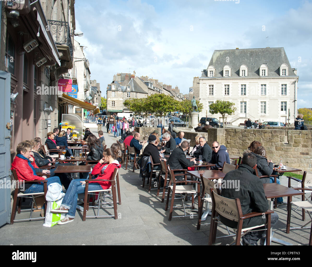 Les gens assis à l'extérieur, dans un café de la Place Duclos, à Dinan, Bretagne, France Banque D'Images