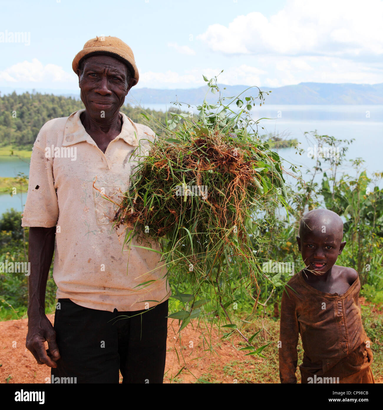 Un homme de fermes par le lac Kivu au Rwanda. Il se distingue par un garçon. Banque D'Images