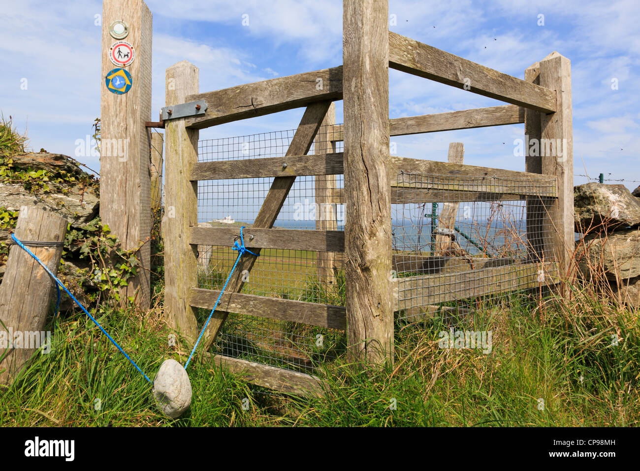 Un kissing gate sur l'île d'Anglesey Sentier du littoral avec un poids en pierre de la clôture. Llaneilian Anglesey au nord du Pays de Galles Royaume-uni Grande-Bretagne Banque D'Images