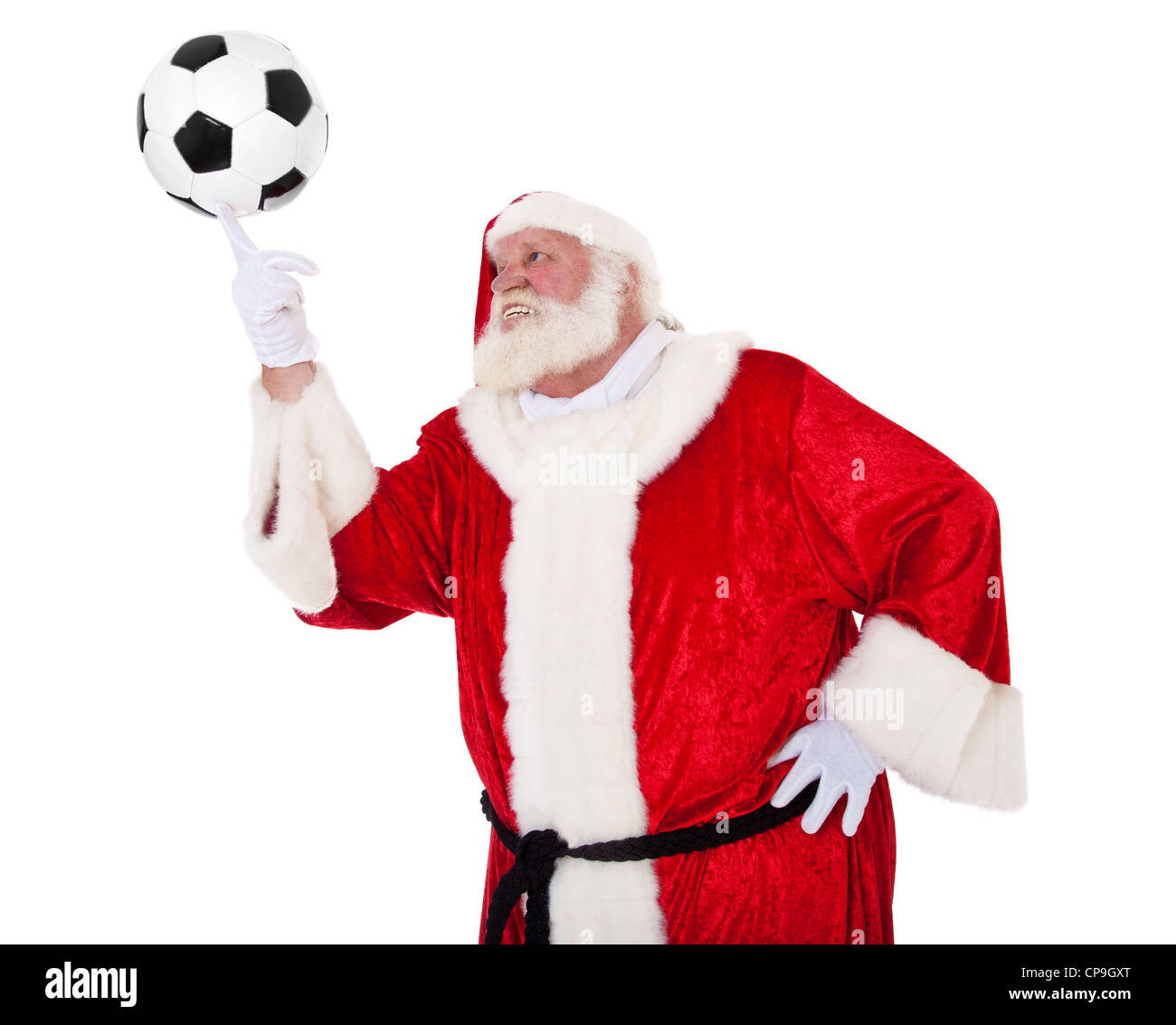 Père Noël en aspect authentique à jouer avec un ballon de football. Le tout sur fond blanc. Banque D'Images