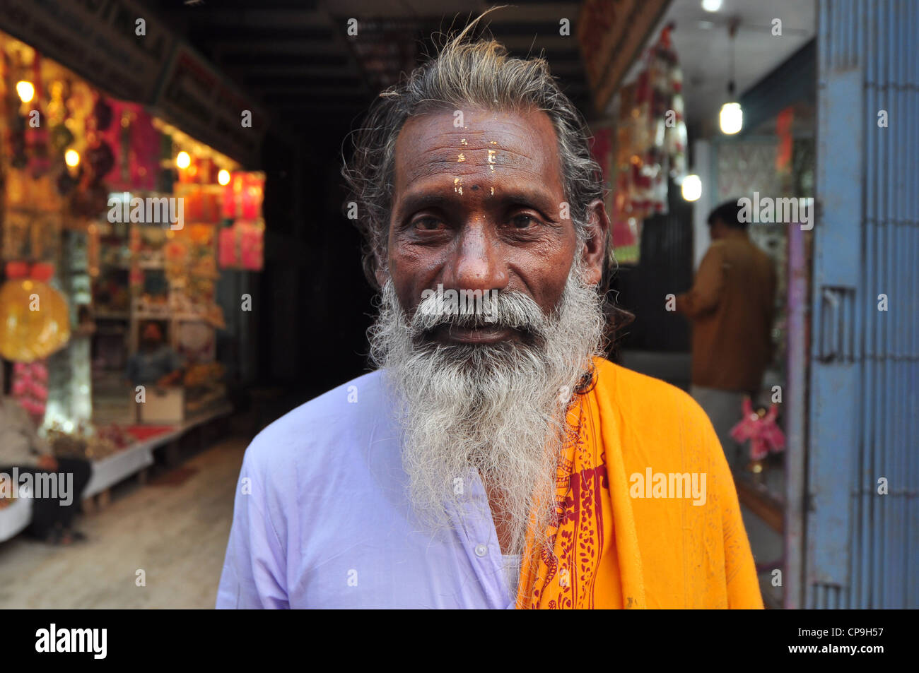 Un vieux sadhu Indien avec une barbe et un tilak sur le front friendly regardant la caméra sur la rue de Vrindavan. Banque D'Images
