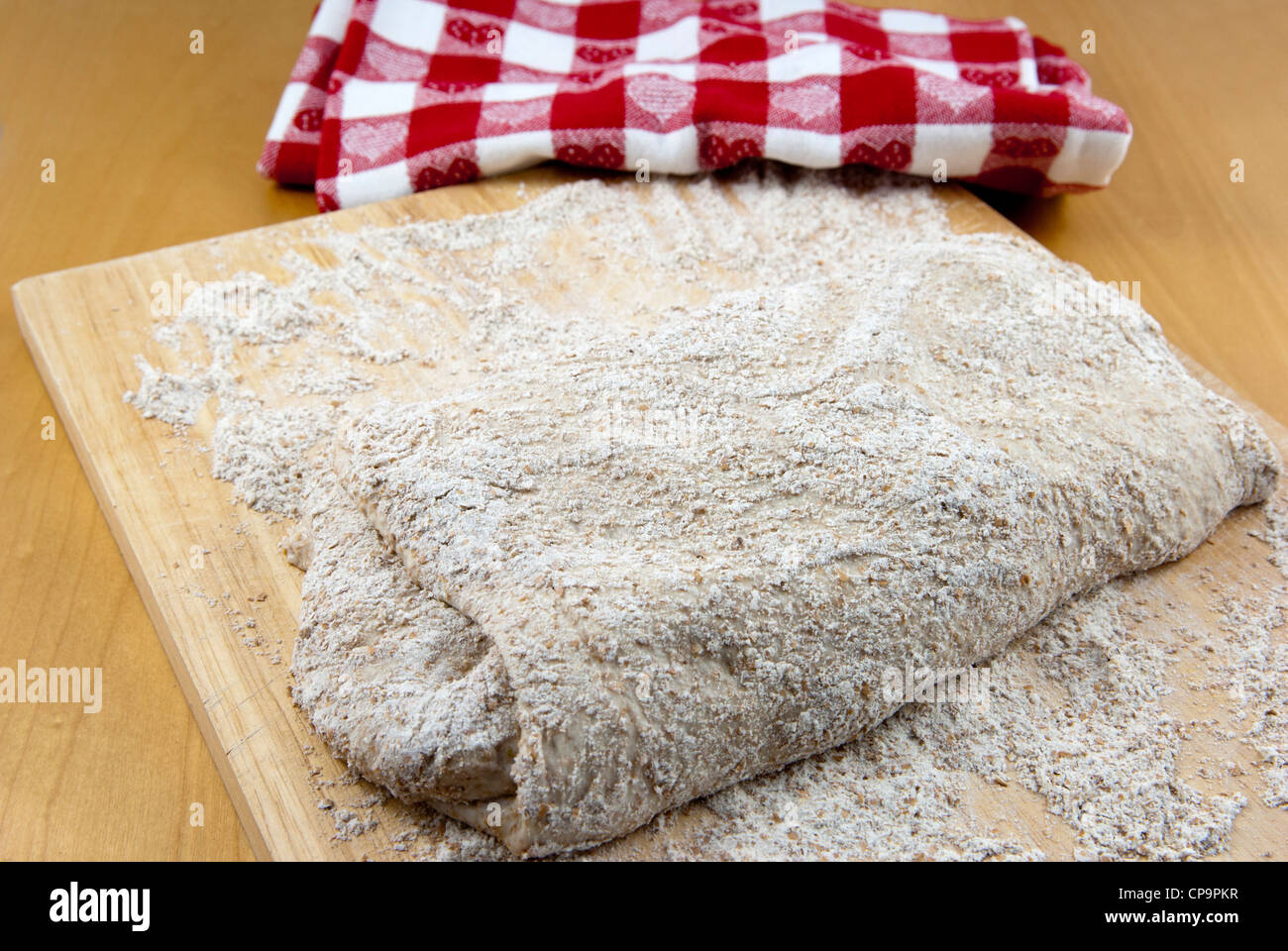 Étape 4 dans la préparation d'un pas de pétrir le pain au levain artisan, pliage de la pâte étirée. Banque D'Images