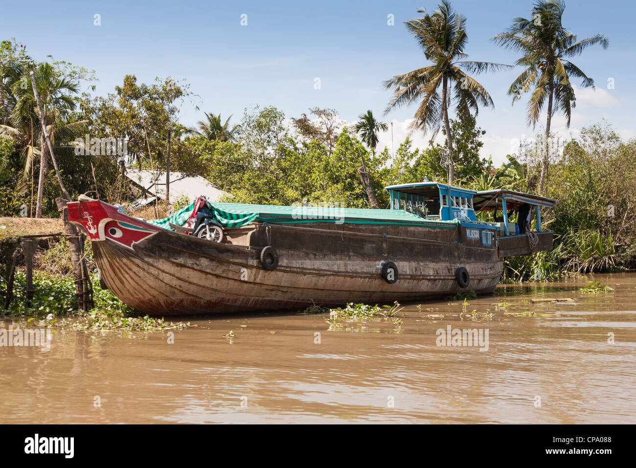 Un bateau typique à un amarrage riverside, Cai Be, Delta du Mekong, Vietnam Banque D'Images