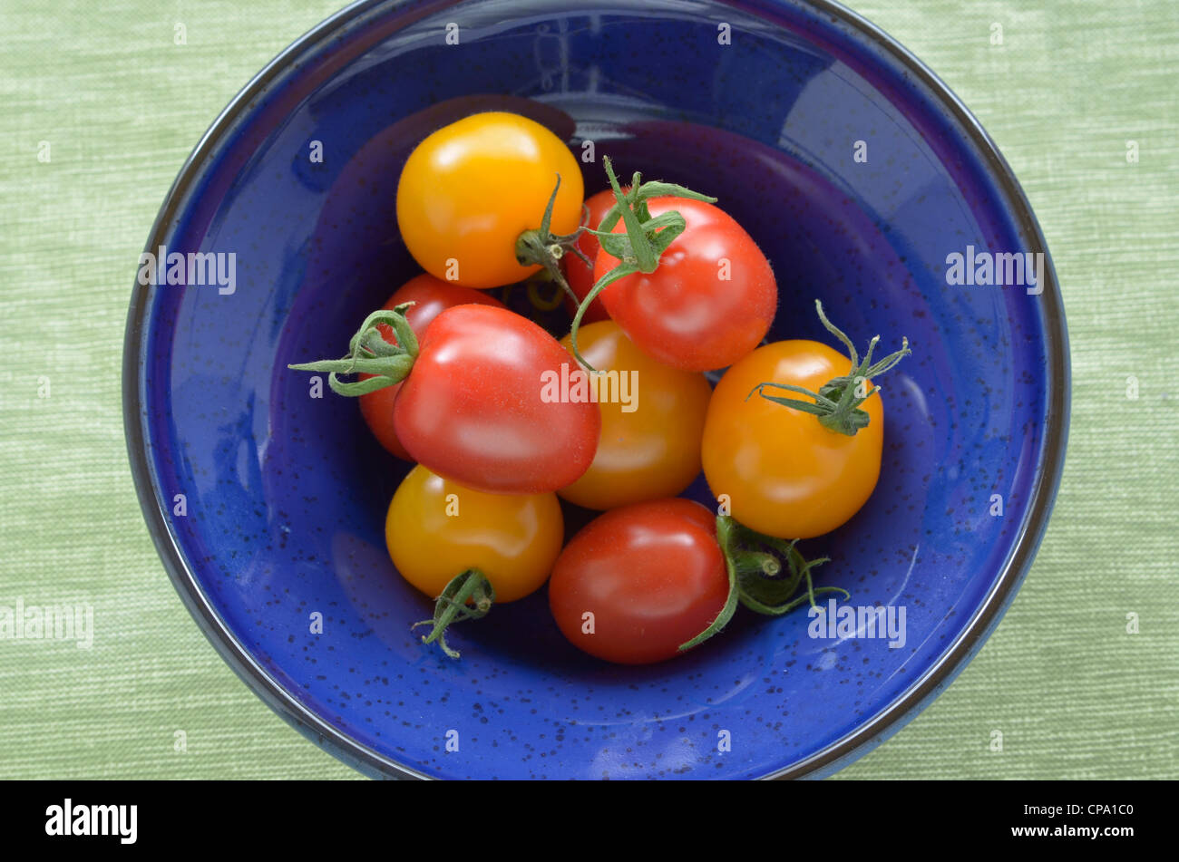 Tomates cerises jaunes et rouges en bleu bol émaillés Banque D'Images