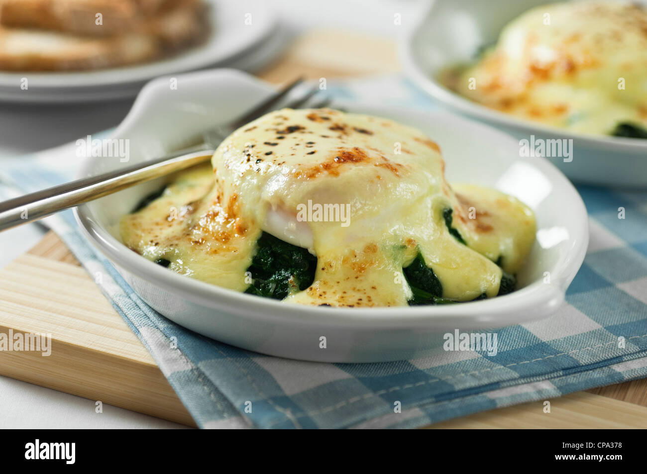 Oeufs florentine. Les oeufs pochés sur les épinards avec sauce au fromage. Banque D'Images
