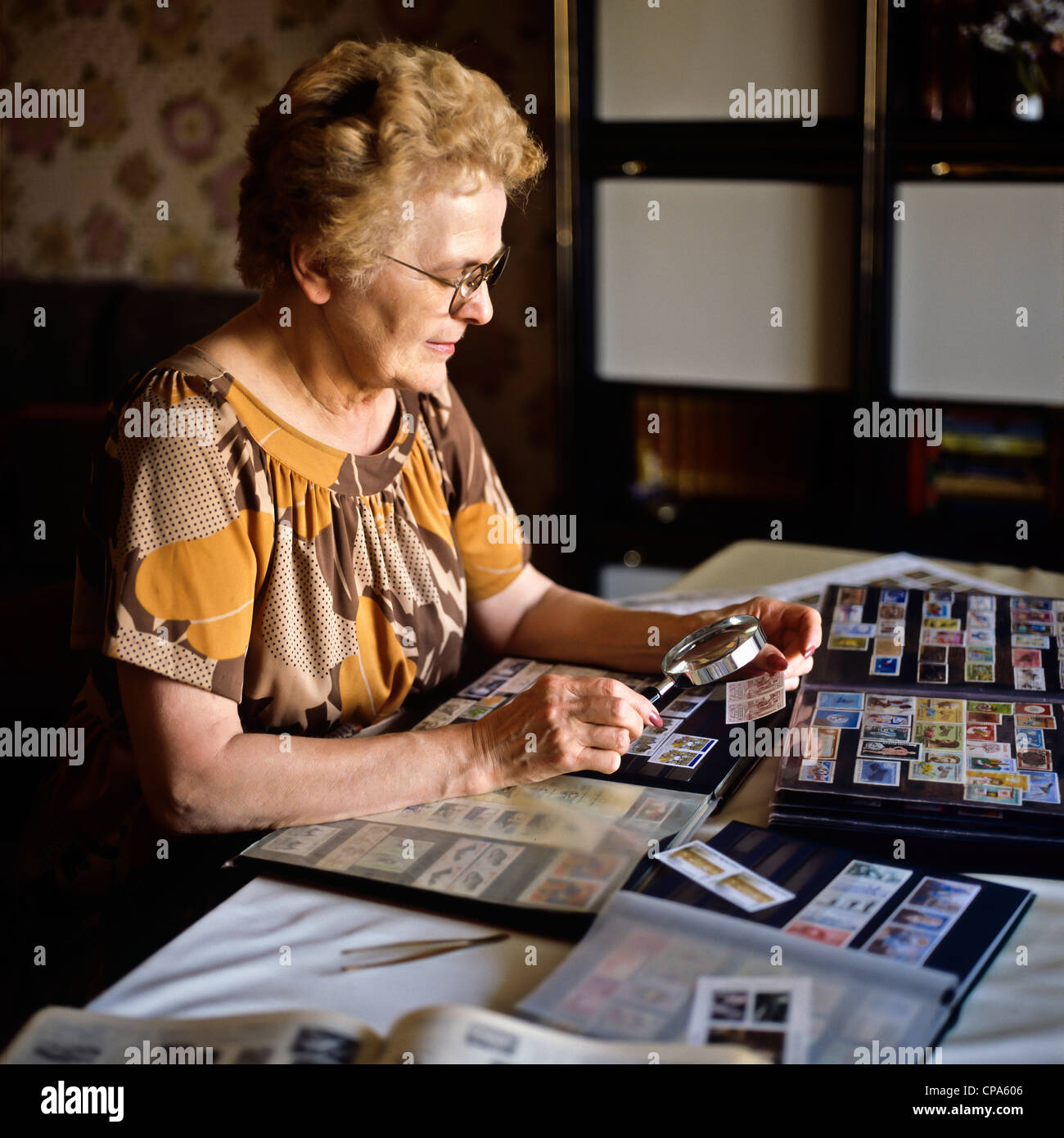 Monsieur femme âgée avec collection de timbres-poste Banque D'Images