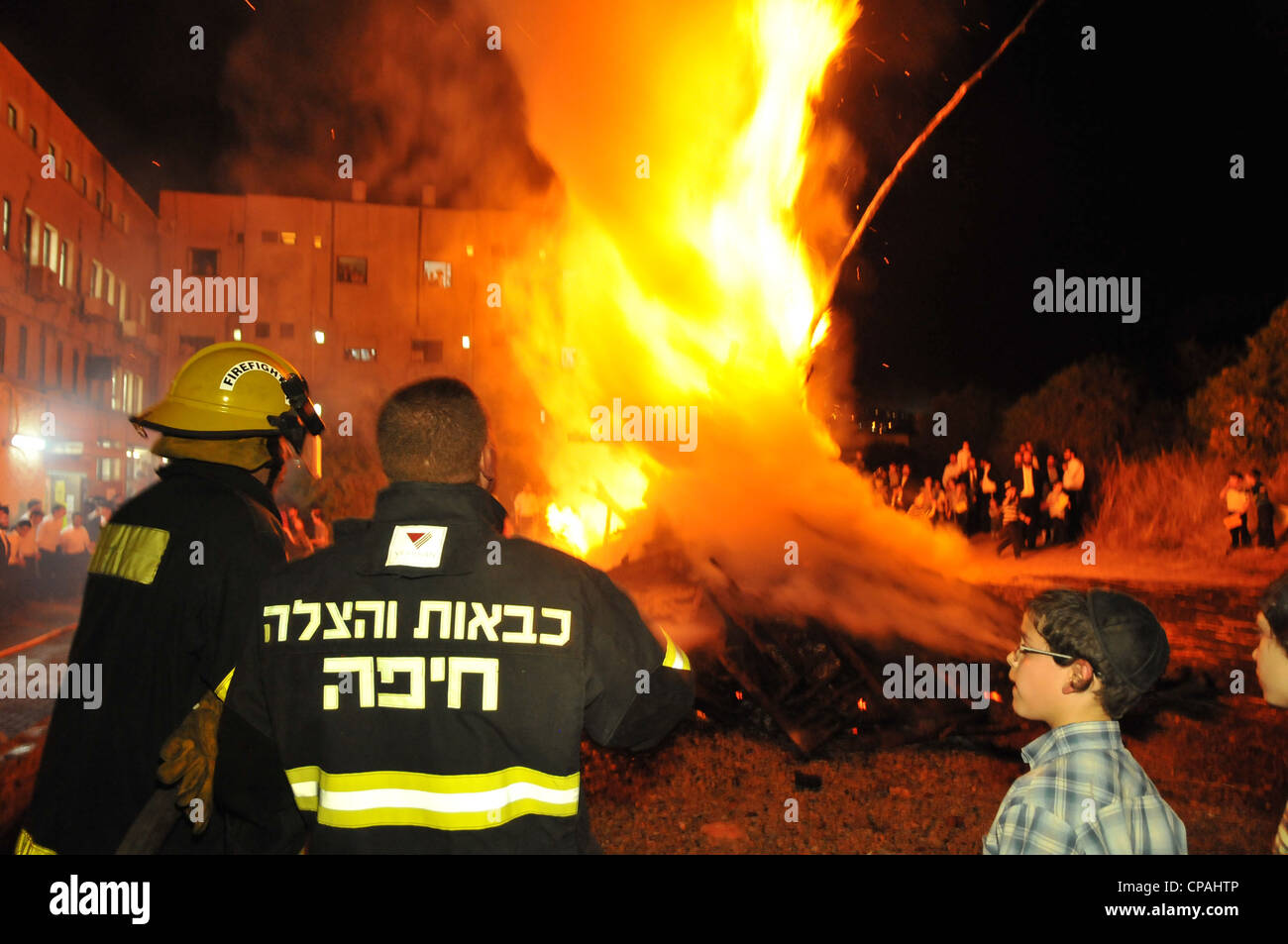 Un pompier éteint un incendie qui était hors de contrôle au cours de la célébration de la fête juive de Lag BaOmer à Haïfa. Banque D'Images