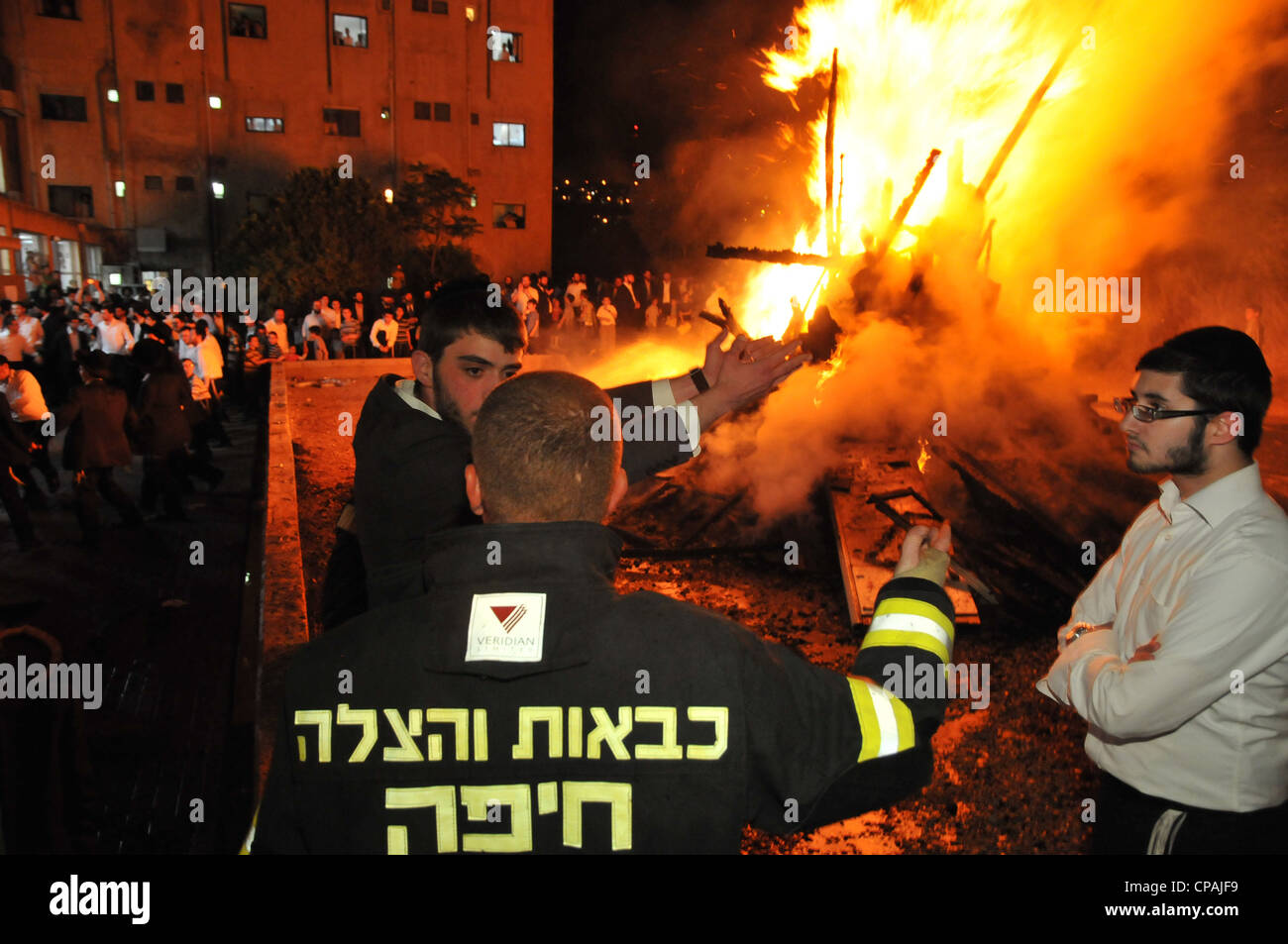 Un pompier éteint un incendie qui était hors de contrôle au cours de la célébration de la fête juive de Lag BaOmer à Haïfa. Banque D'Images