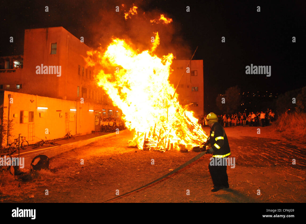 Un pompier éteint un incendie qui était hors de contrôle au cours de la célébration de la fête juive de Lag BaOmer à Haïfa. Banque D'Images