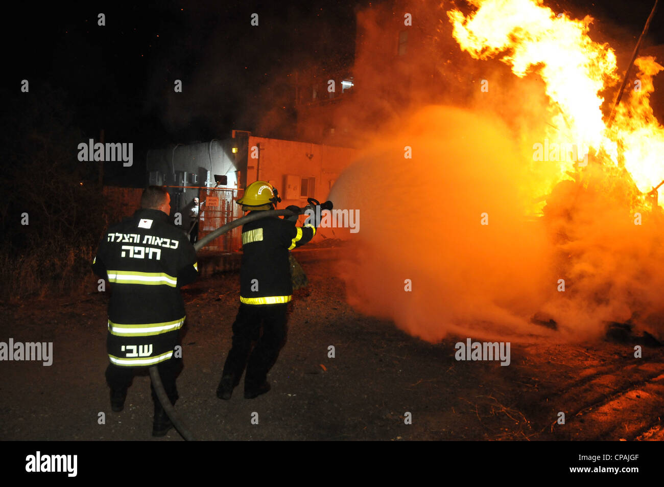 Un pompier éteint un incendie qui était hors de contrôle au cours de la célébration de la fête juive de Lag BaOmer à Haïfa. Banque D'Images