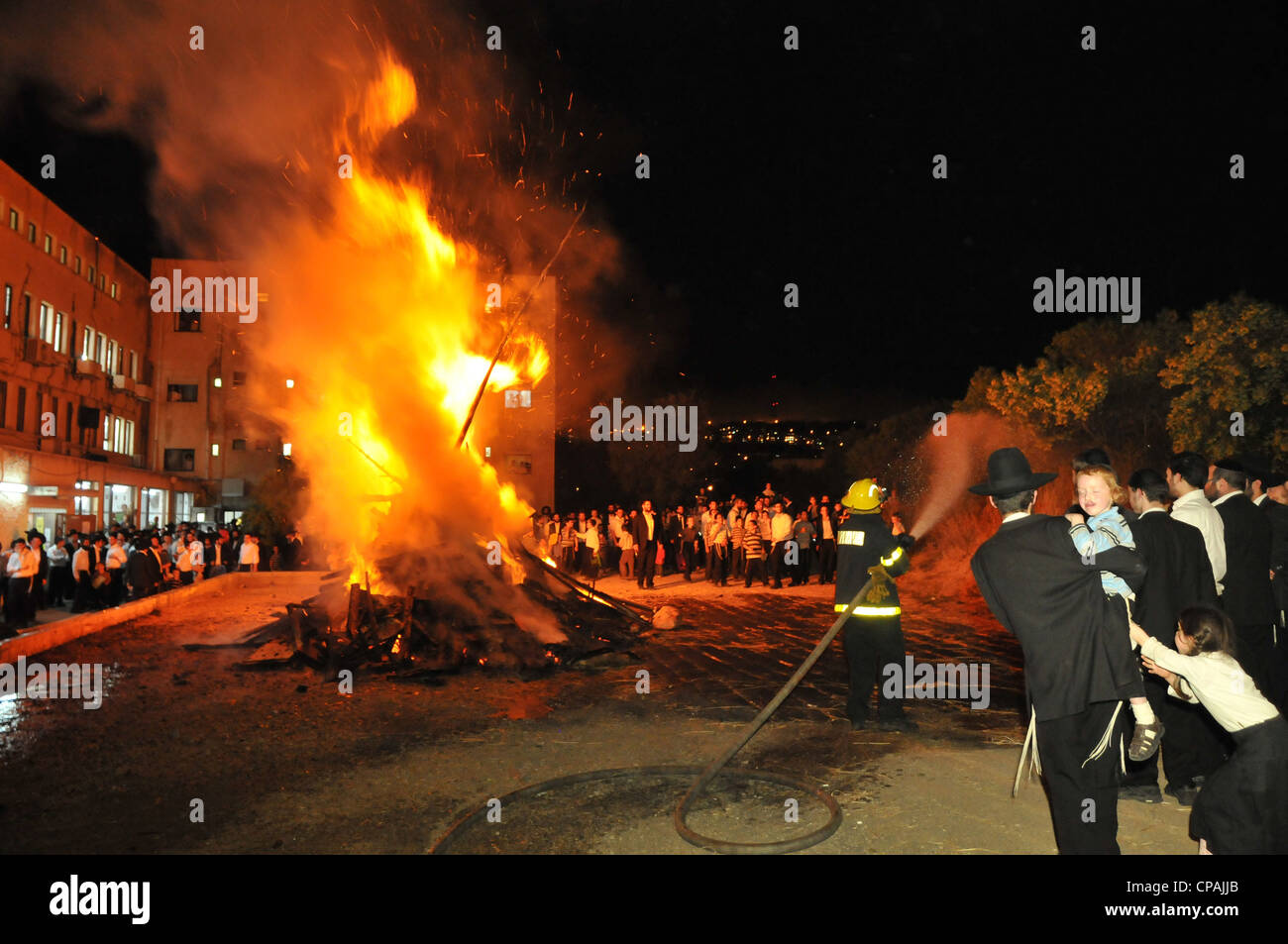 Un pompier éteint un incendie qui était hors de contrôle au cours de la célébration de la fête juive de Lag BaOmer à Haïfa. Banque D'Images