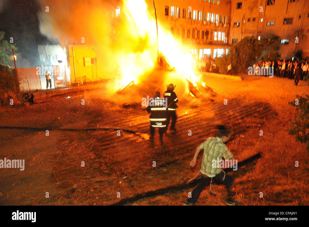 Un pompier éteint un incendie qui était hors de contrôle au cours de la célébration de la fête juive de Lag BaOmer à Haïfa. Banque D'Images