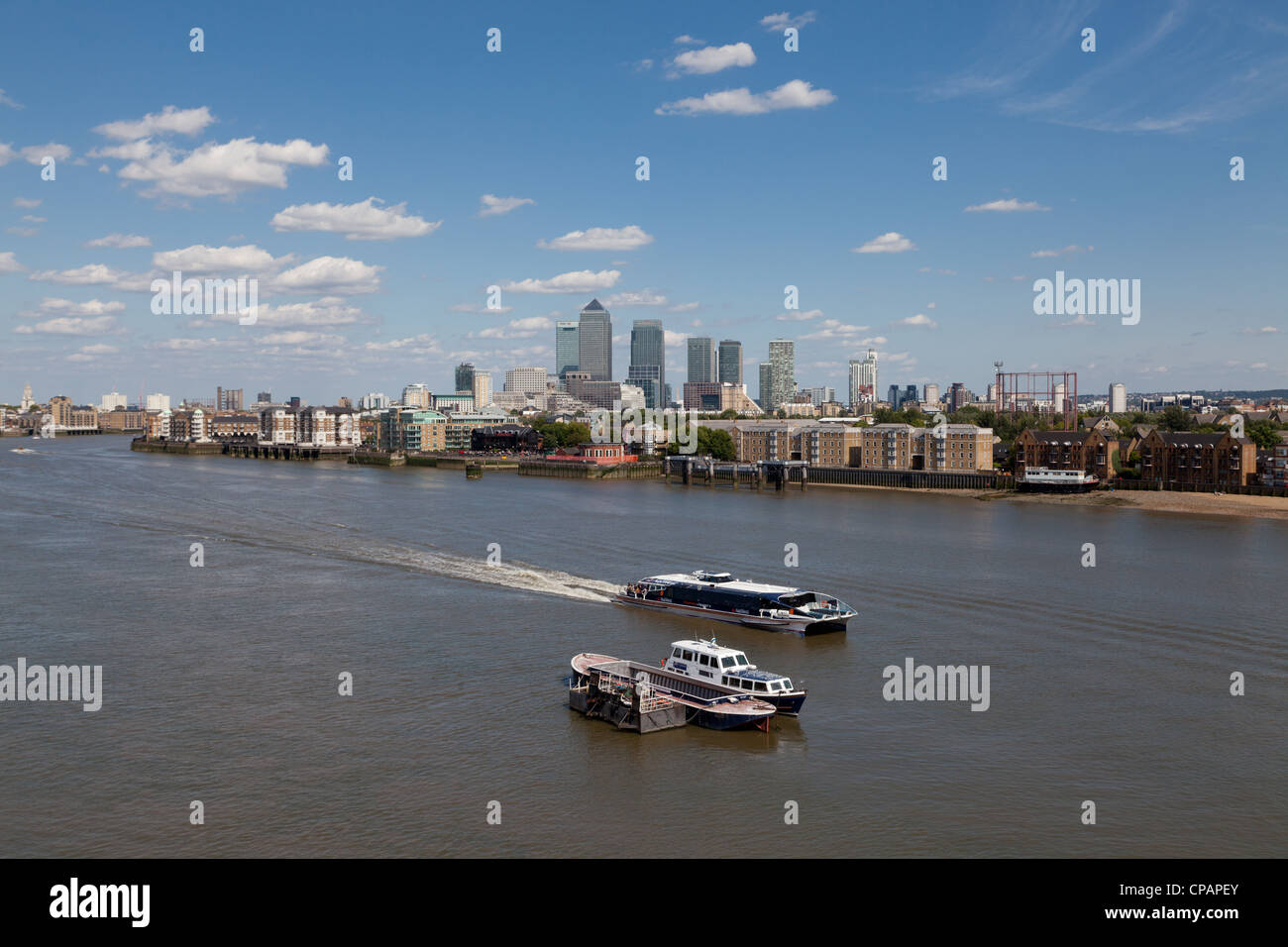 Thames Clipper ferry sur la Tamise est de Londres, vue vers les Docklands de Londres, Canary Wharf à distance Banque D'Images