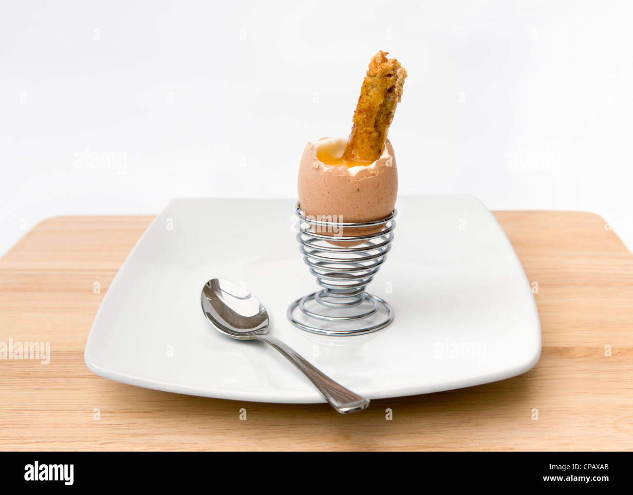 Soldats et toast en metal egg cup sur fond blanc Banque D'Images