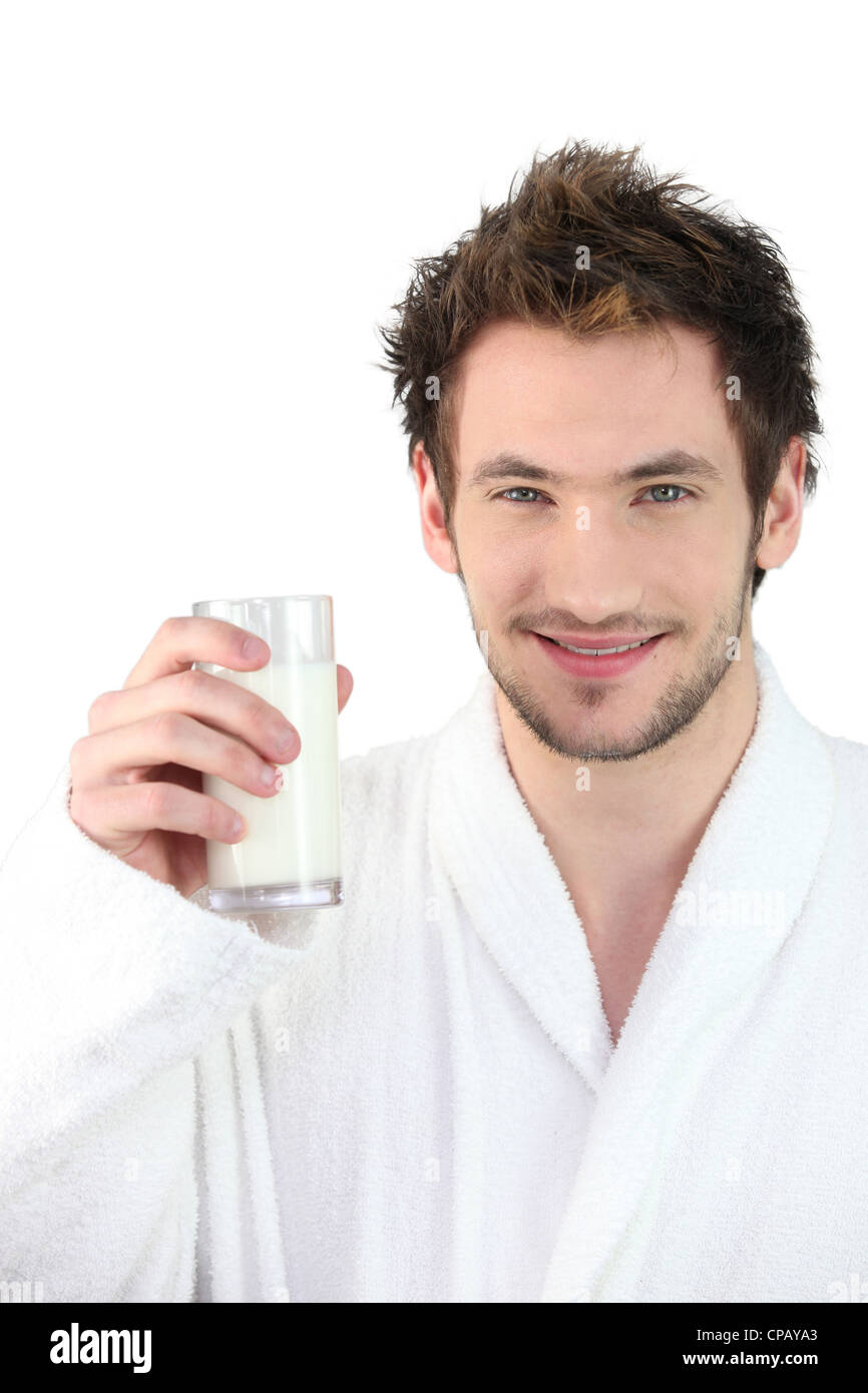 L'homme en robe de chambre, de boire dans un verre de lait Banque D'Images