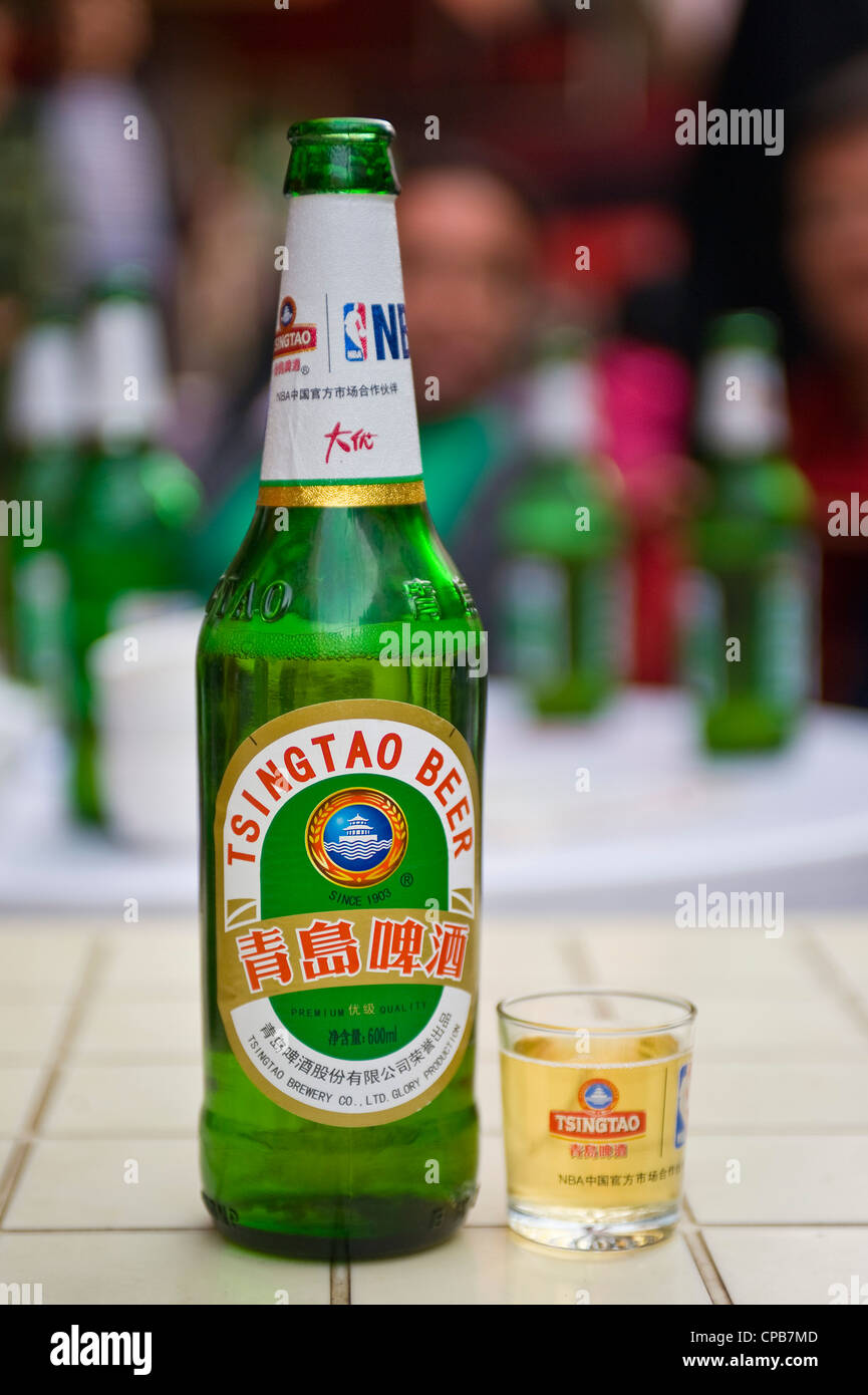 Une bouteille et un verre de bière Tsingtao sur une table à l'extérieur  d'un marché dans la ville de Lanzhou Photo Stock - Alamy