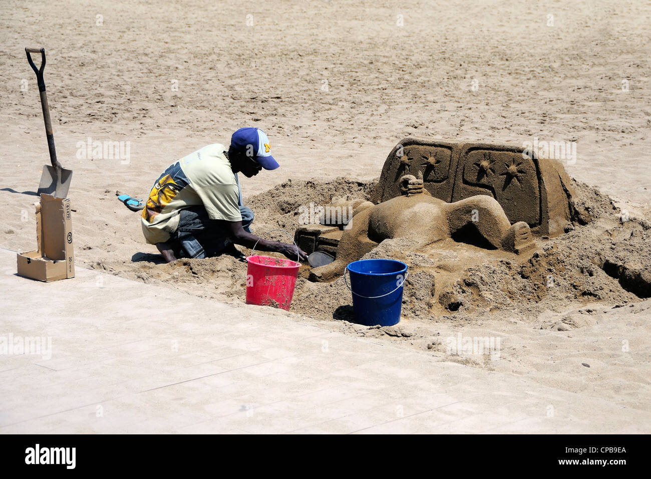 Un chien à la sculpture de sable Platja de Sant Sebastià plage de la Barceloneta, Barcelone, Espagne. Banque D'Images