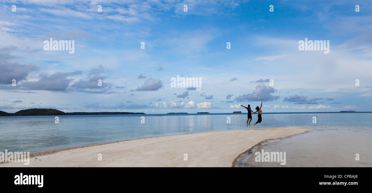 Couple heureux de sauter sur la plage indonésienne. Banque D'Images
