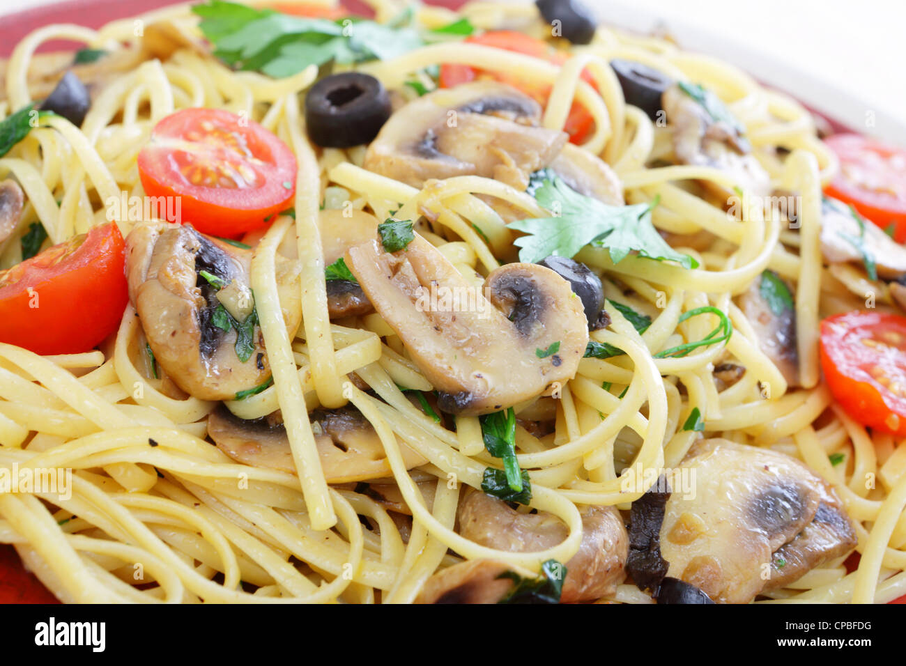 Une assiette de spaghetti sautées dans une sauche d'huile d'olive, champignons, l'ail et basilic, Banque D'Images
