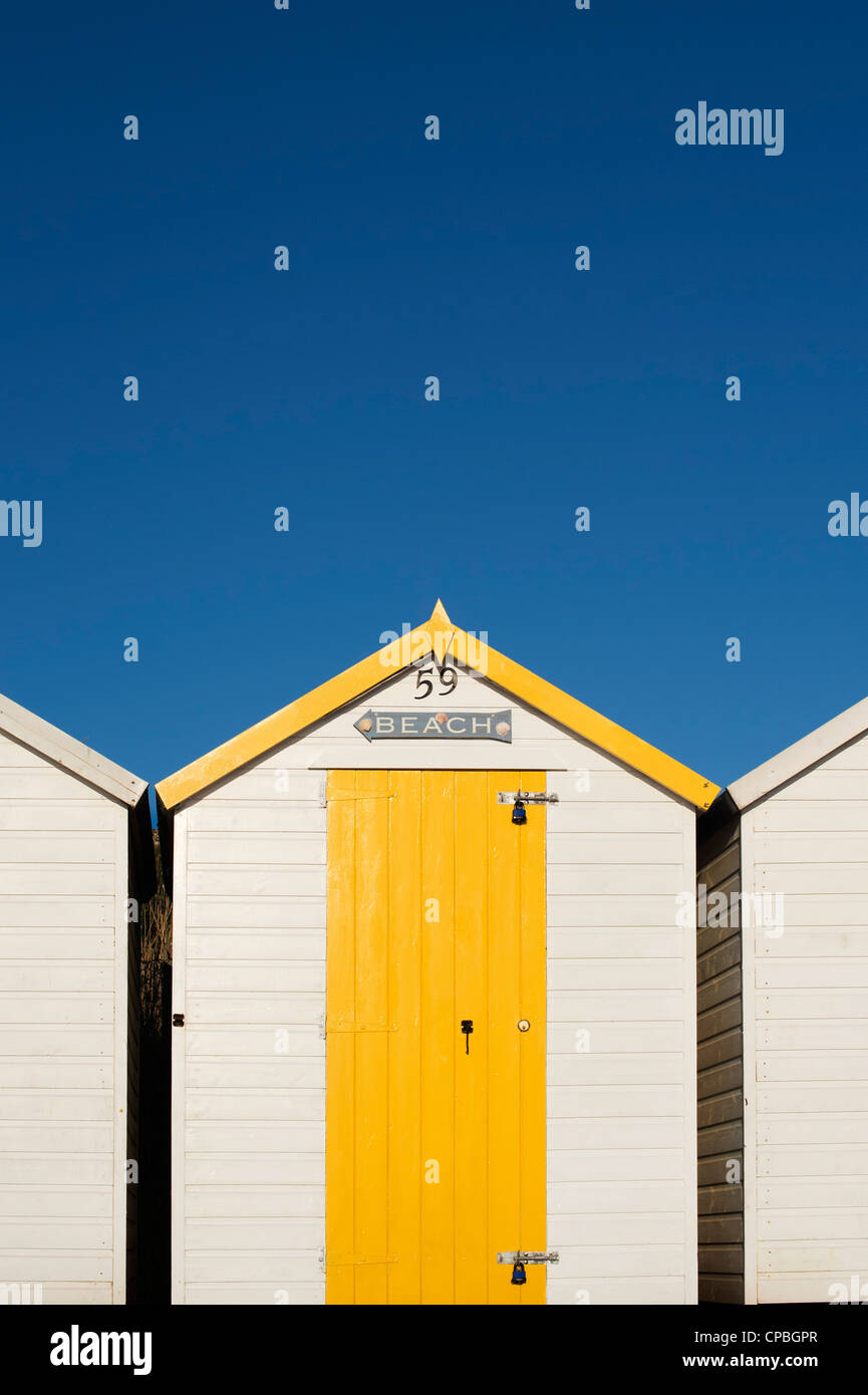 Cabane de plage jaune colorés sur fond de ciel bleu. Plage de Goodrington, Paignton, Devon, Angleterre Banque D'Images