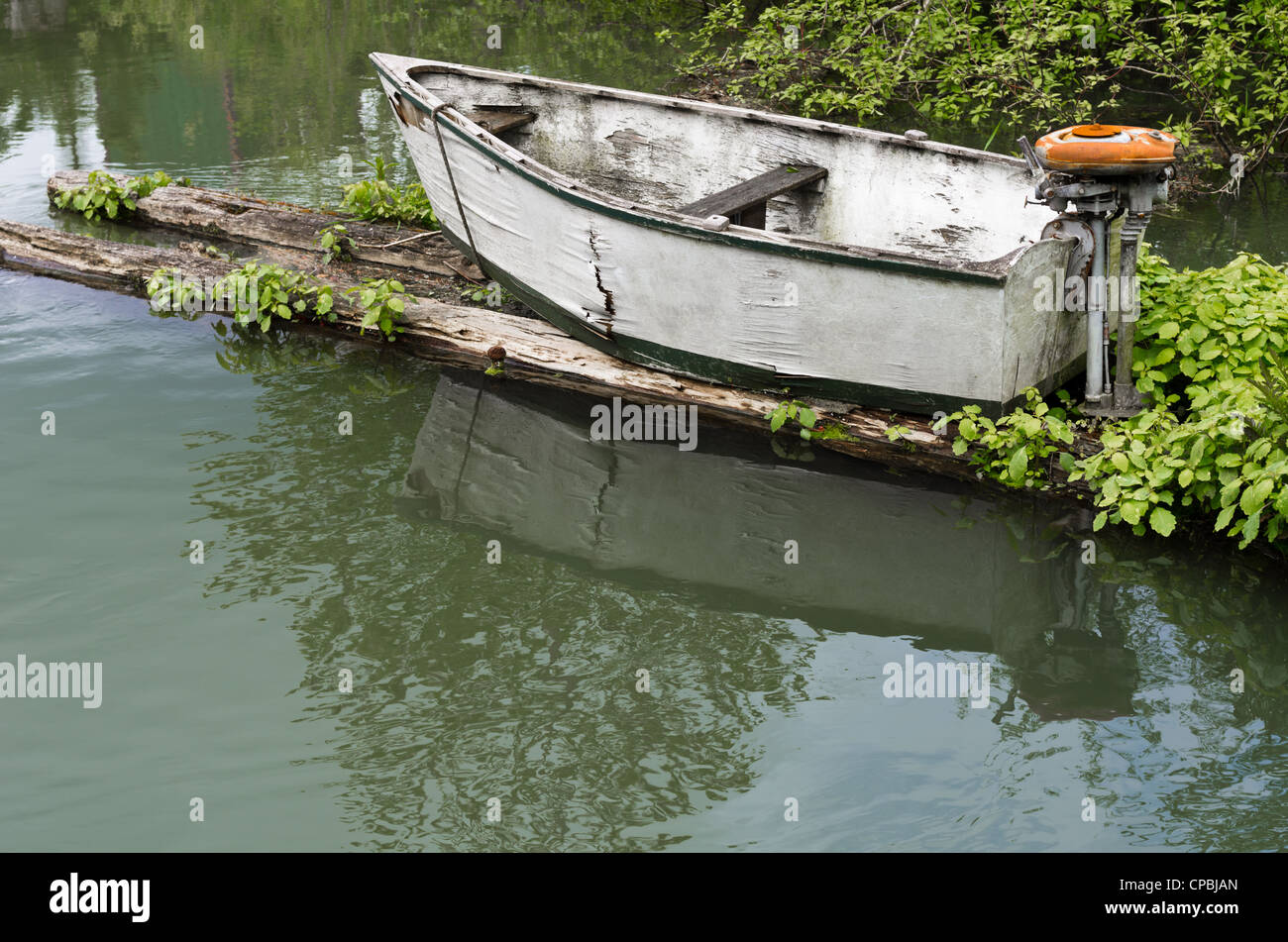 Un petit esquif abandonné avec moteur hors-bord vintage Banque D'Images