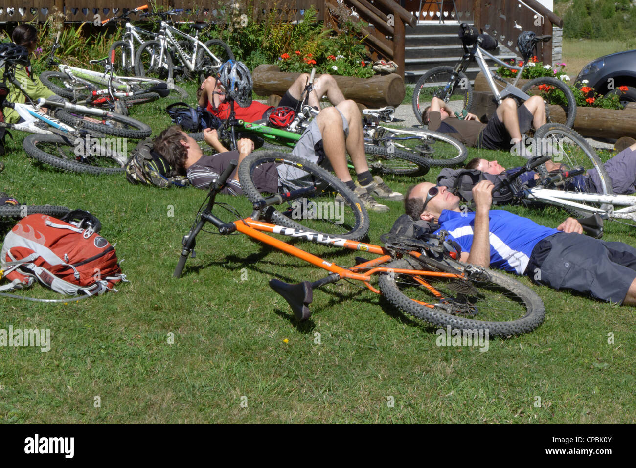 Les cyclistes fatigués de vous détendre sur l'herbe sur le mountain bike Tour du Mont Blanc Banque D'Images