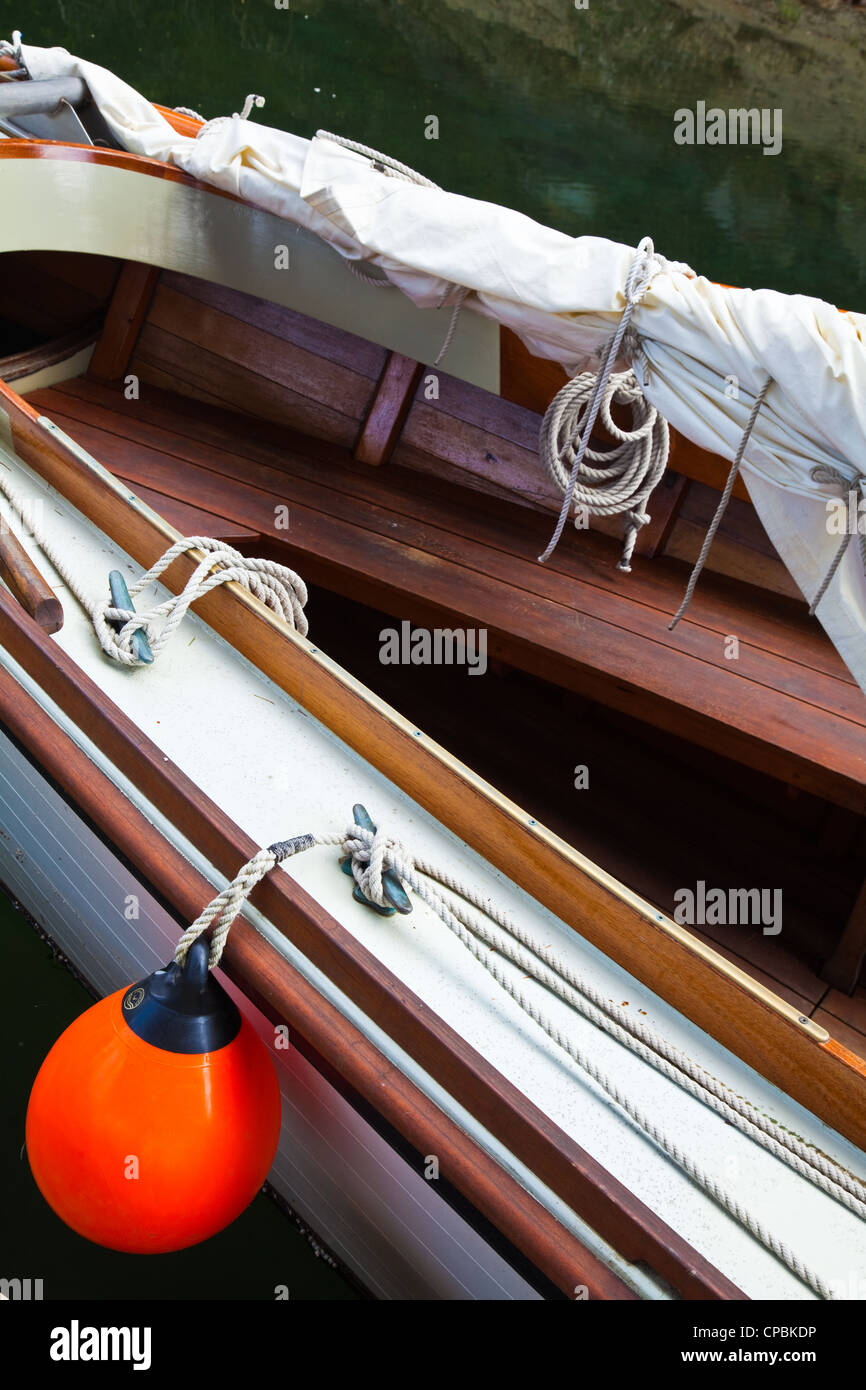 Image abstraite d'un petit navire à voile avec un flotteur orange. Banque D'Images