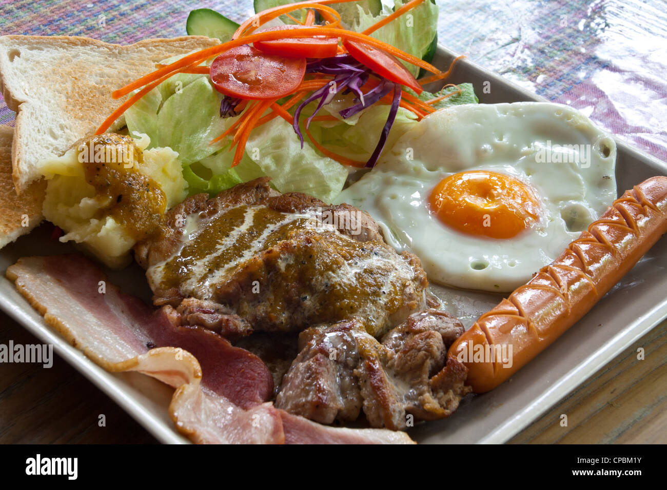 Steak de porc, bacon, œuf frit, de saucisses, de pain et de la salade. Banque D'Images