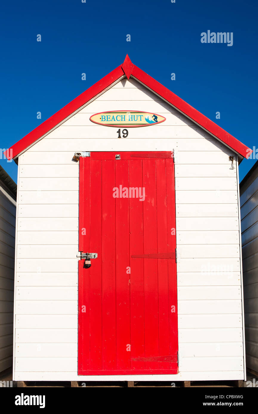 Cabane de plage rouge colorés sur fond de ciel bleu. Plage de Goodrington, Paignton, Devon, Angleterre Banque D'Images