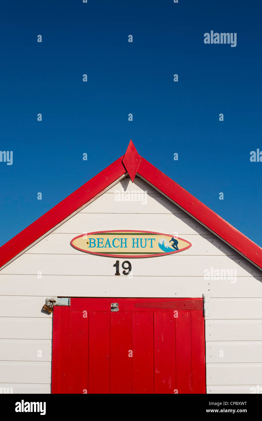 Cabane de plage rouge colorés sur fond de ciel bleu. Plage de Goodrington, Paignton, Devon, Angleterre Banque D'Images