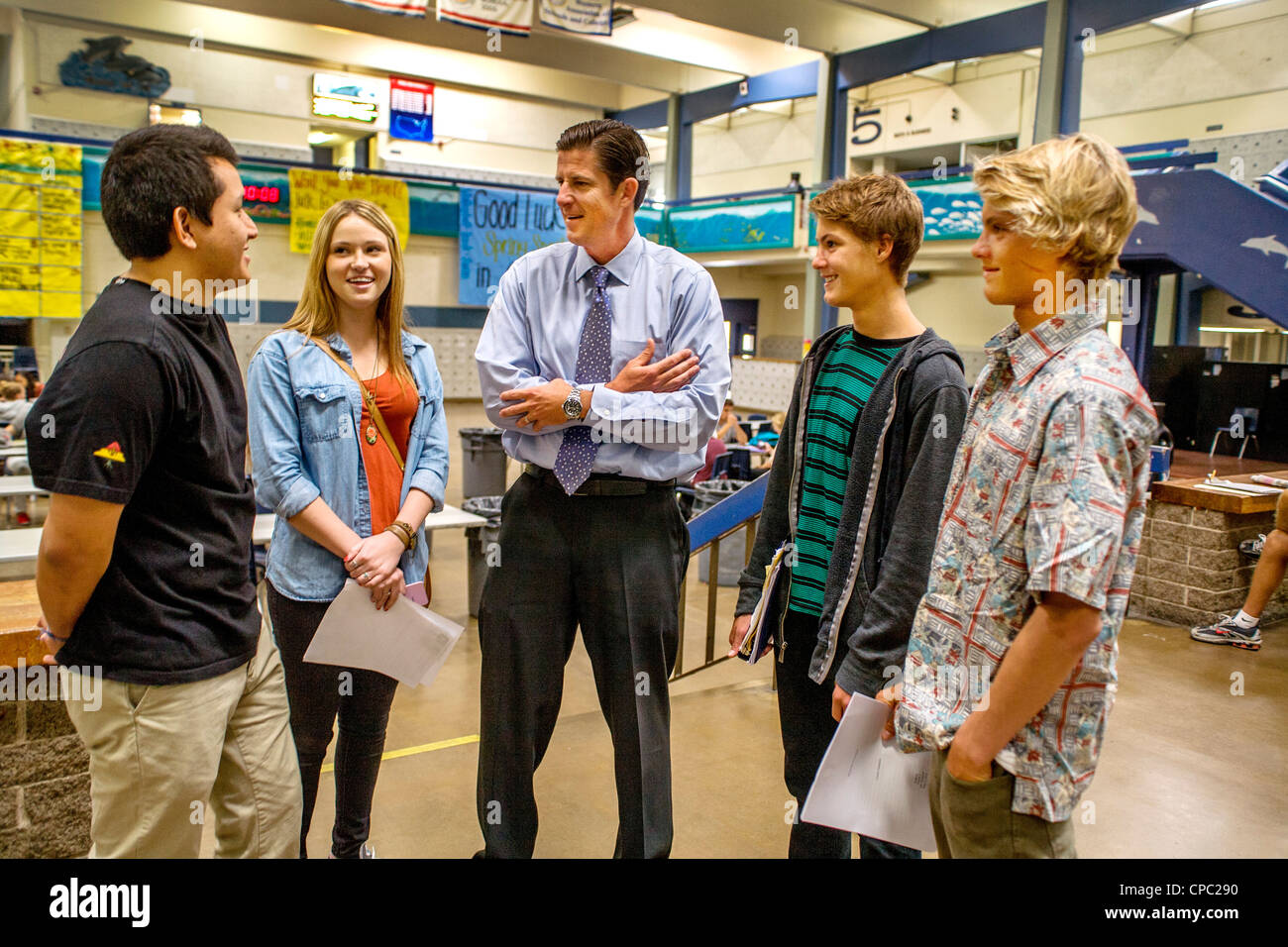 Un directeur de l'école entretiens avec quatre de ses élèves dans le bâtiment de l'école atrium dans Dana Point, CA. Banque D'Images